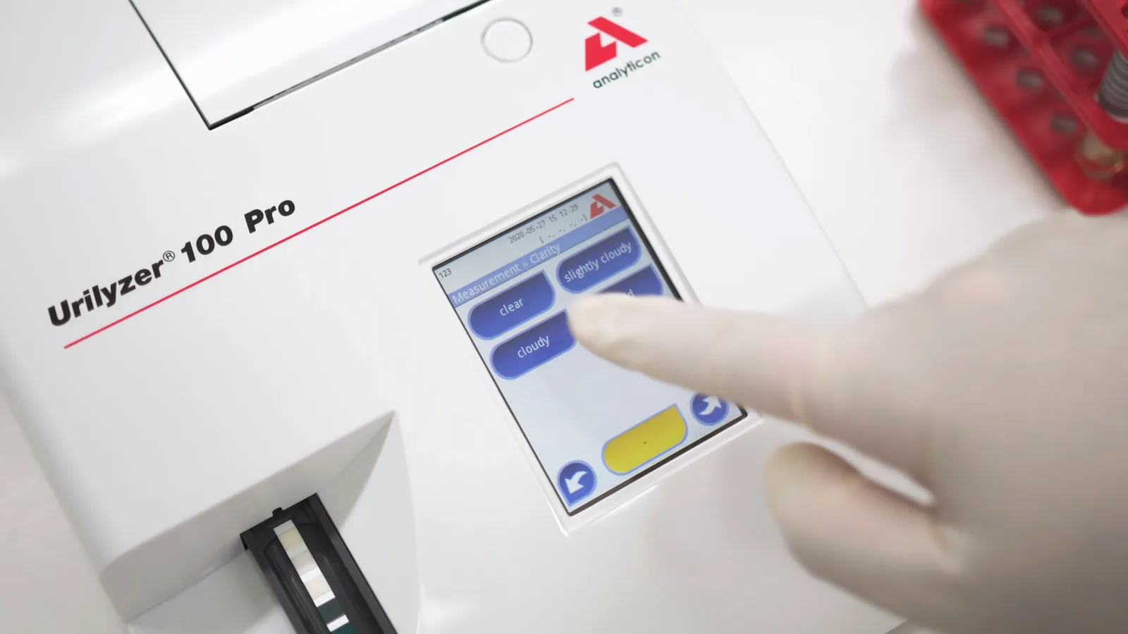 Operator cu mănuși utilizând ecranul tactil al Urilyzer 100 Pro